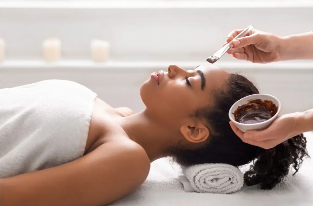 black woman getting a facial treatment at a luxury spa